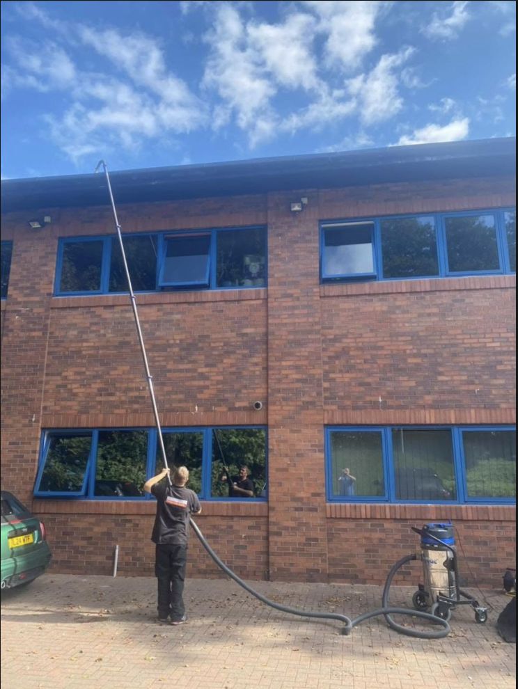 Dave Wood cleaning commercial property windows with professional water-fed pole system in South Manchester