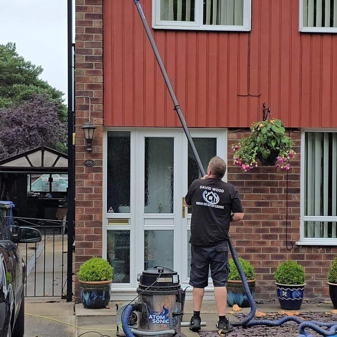Dave Wood using water-fed pole to clean windows at a residential property in South Manchester